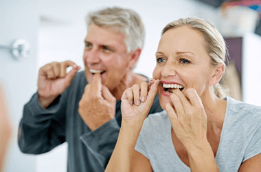 a couple flossing their dental implants together