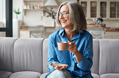 a woman with dental implants enjoying a cup of coffee