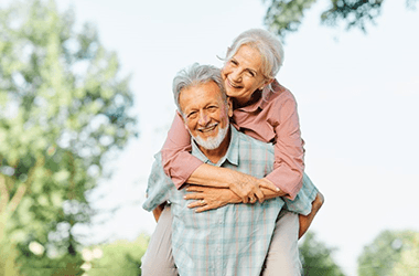 a mature couple with dental implants smiling together