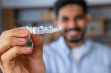 Closeup of patient holding Invisalign aligner